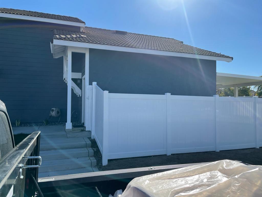 White PVC privacy fence along a side yard