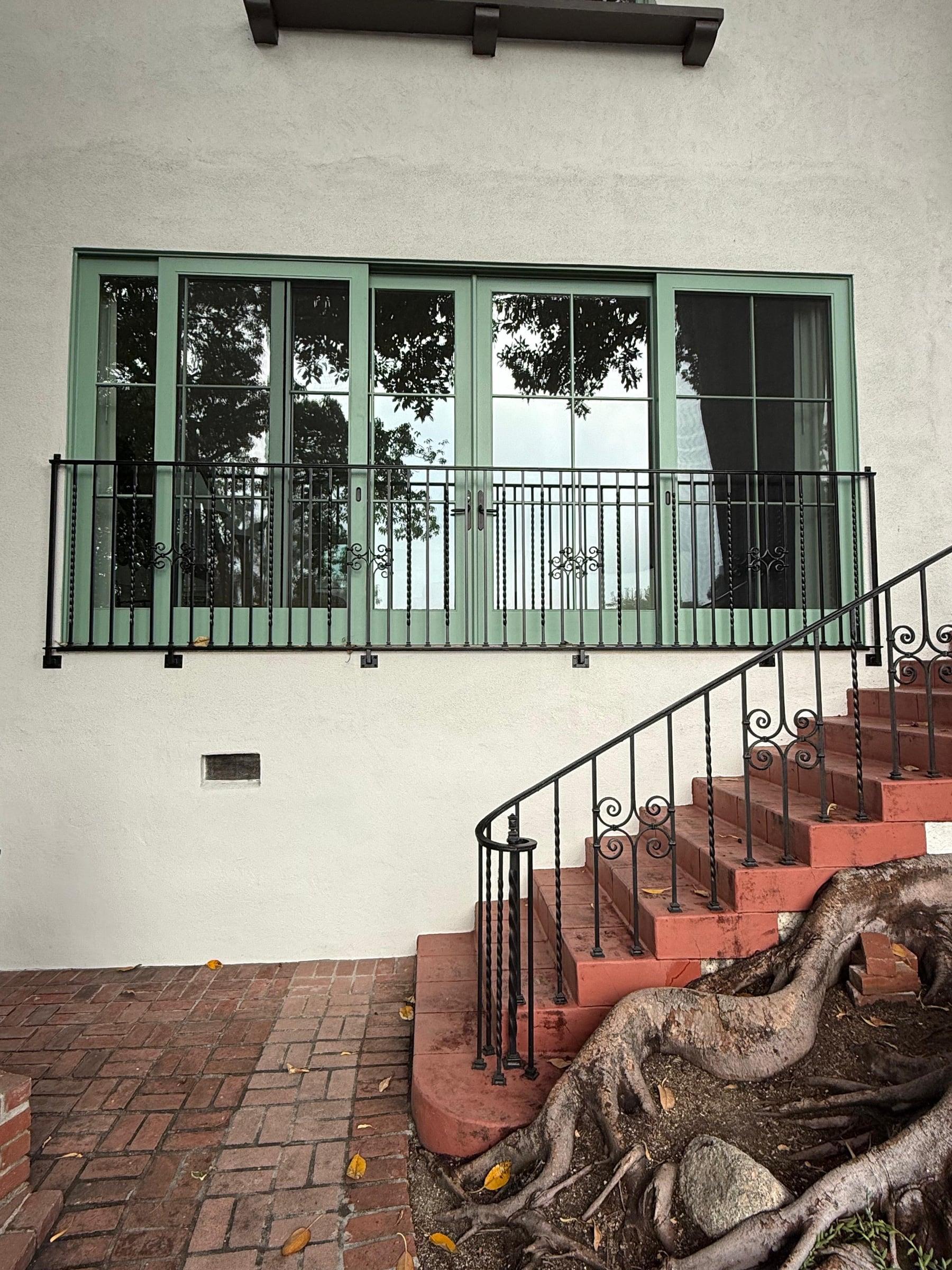 Custom arched metal trellis structure spanning a side yard walkway