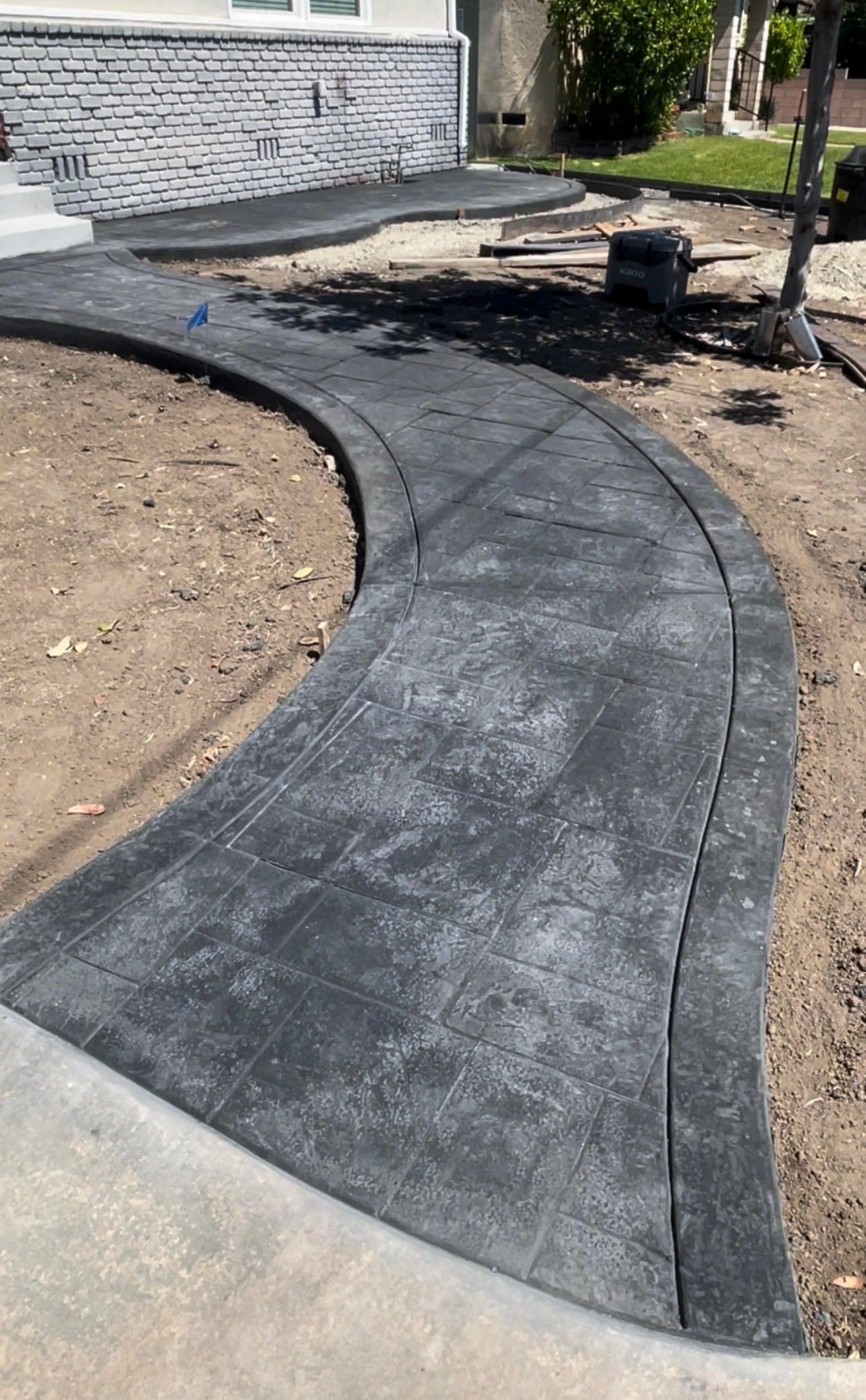 New stamped concrete walkway leading to a front entry