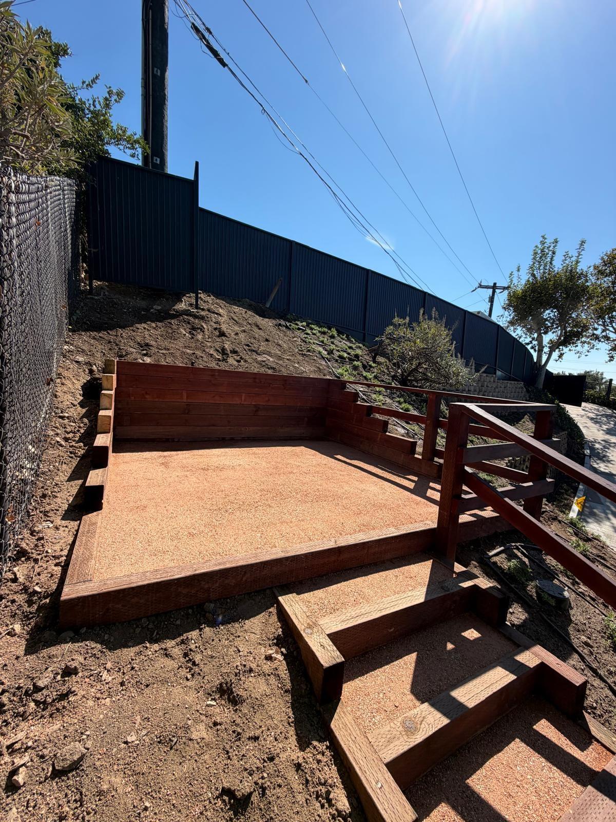 Hillside redwood wall with a decomposed granite patio pad