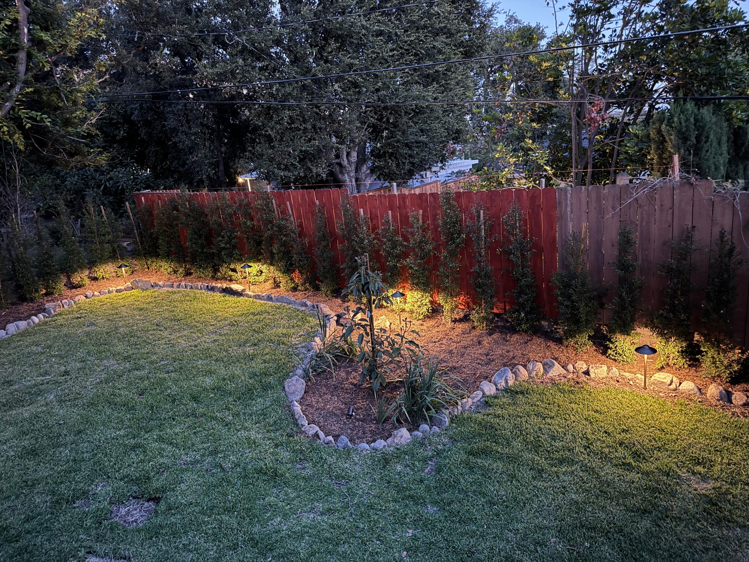 Backyard lawn with a curved, rock-edged planting bed