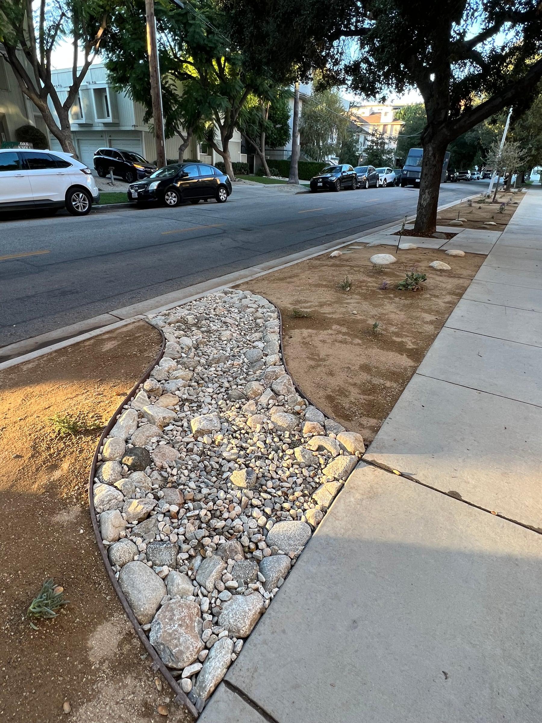 Parkway strip with a dry riverbed rock drainage feature